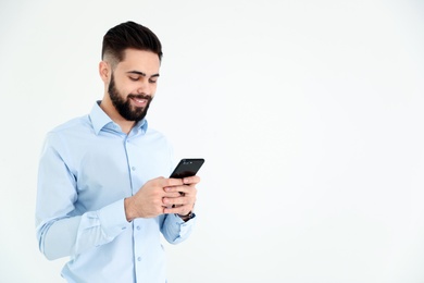 Handsome young man using phone on white background, space for text. Working time