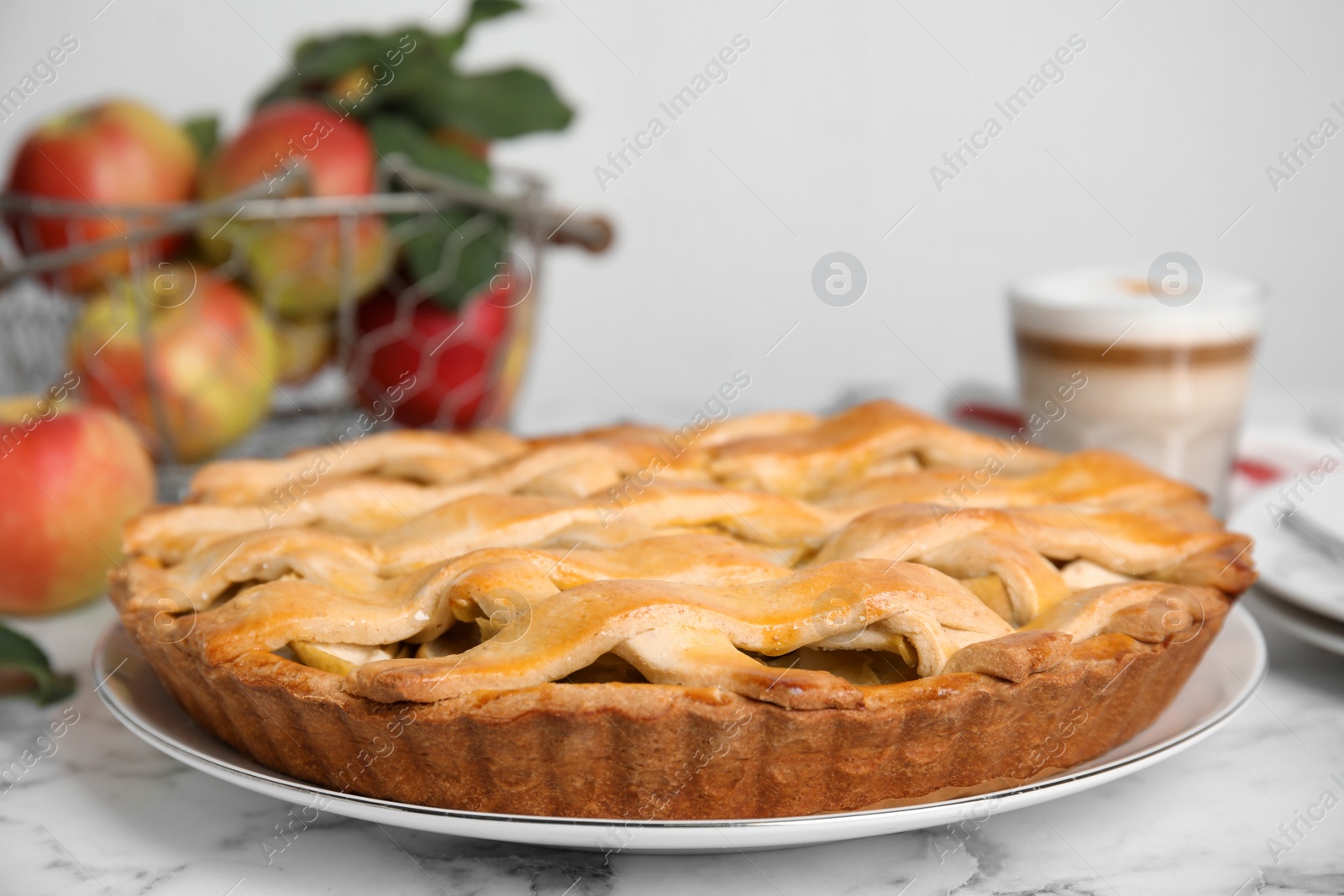 Photo of Delicious traditional apple pie on white marble table, closeup