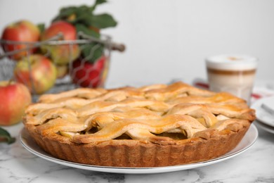 Delicious traditional apple pie on white marble table, closeup