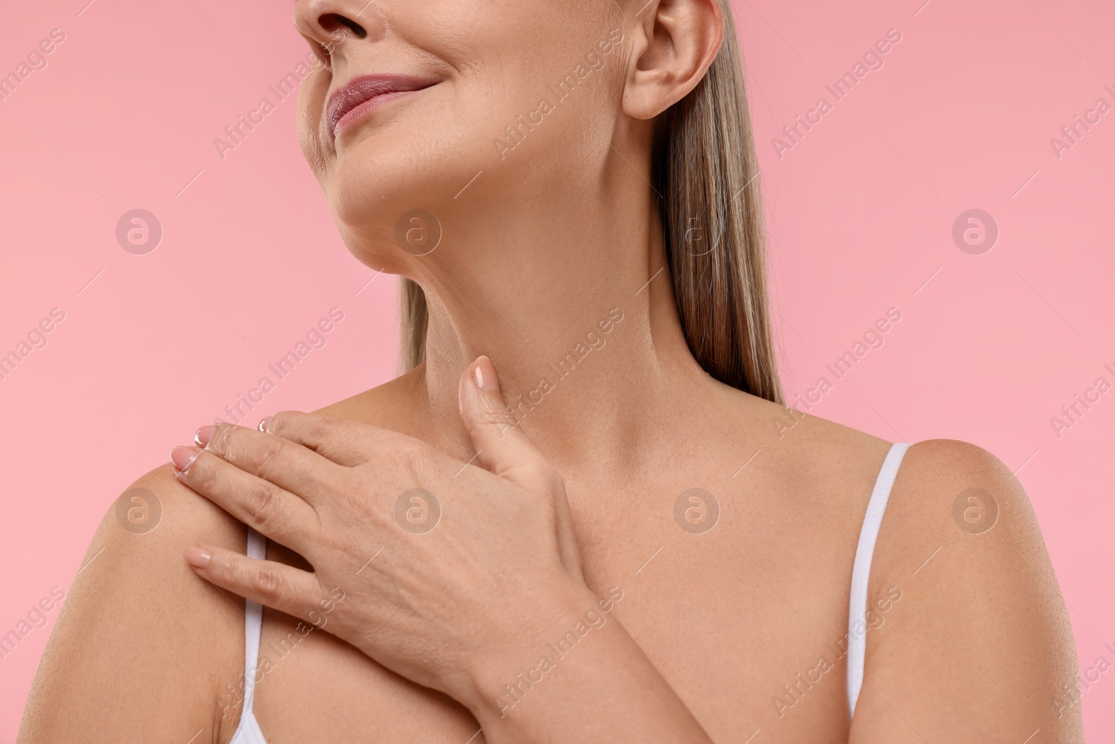 Photo of Mature woman with healthy skin on pink background, closeup