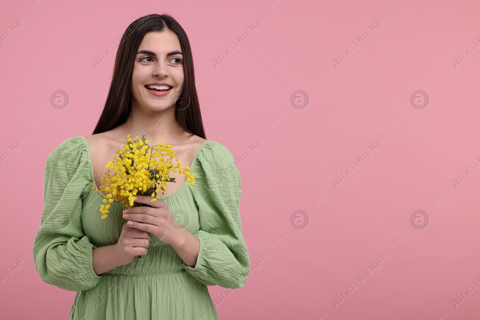 Photo of Happy young woman with beautiful bouquet on dusty pink background. Space for text