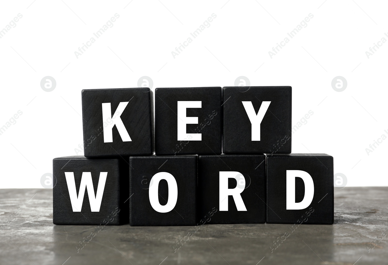 Photo of Black cubes with word KEYWORD on grey table