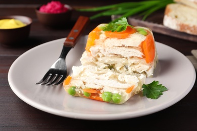 Delicious chicken aspic served on wooden table, closeup