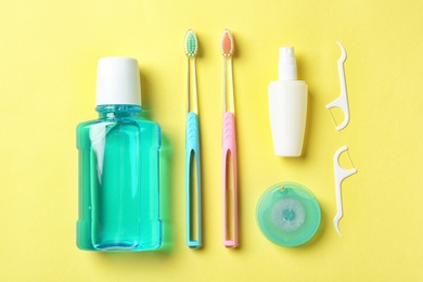 Photo of Flat lay composition with manual toothbrushes and oral hygiene products on color background