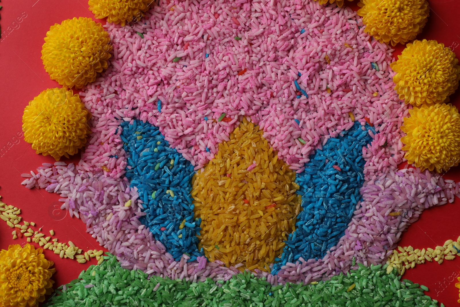 Photo of Happy Diwali. Composition with colorful rangoli and chrysanthemum flowers on red background, top view