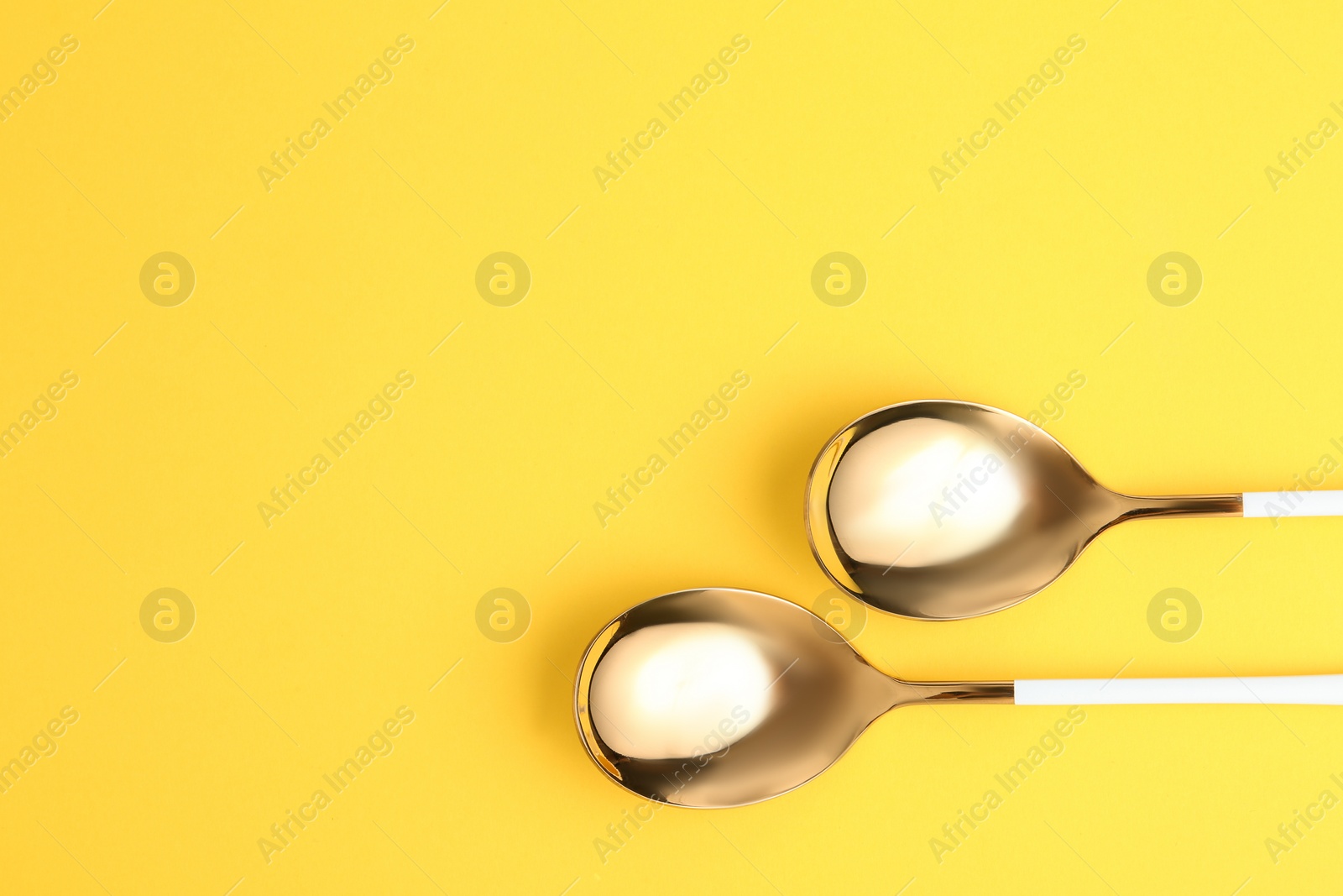 Photo of Clean tablespoons and space for text on color background, flat lay