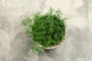 Photo of Bowl of fresh green dill on light grey table, top view