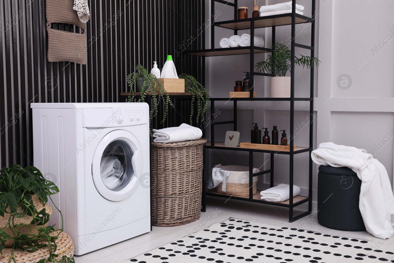 Photo of Laundry room interior with washing machine and stylish furniture