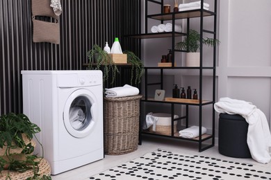 Laundry room interior with washing machine and stylish furniture