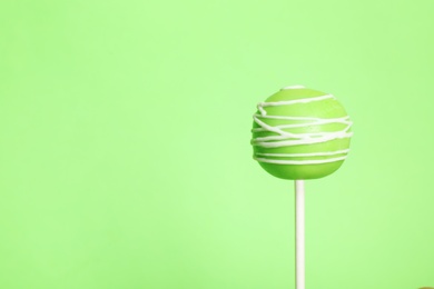 Photo of Bright delicious cake pop on color background. Space for text