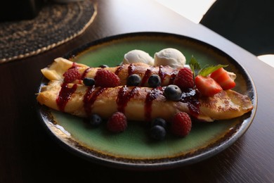 Delicious pancakes with fresh berries and ice cream on wooden table, closeup