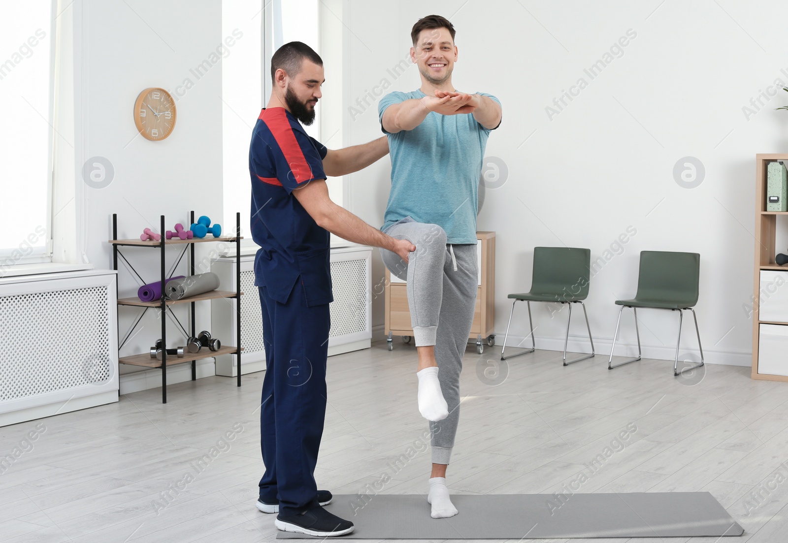 Photo of Physiotherapist working with patient in clinic. Rehabilitation therapy