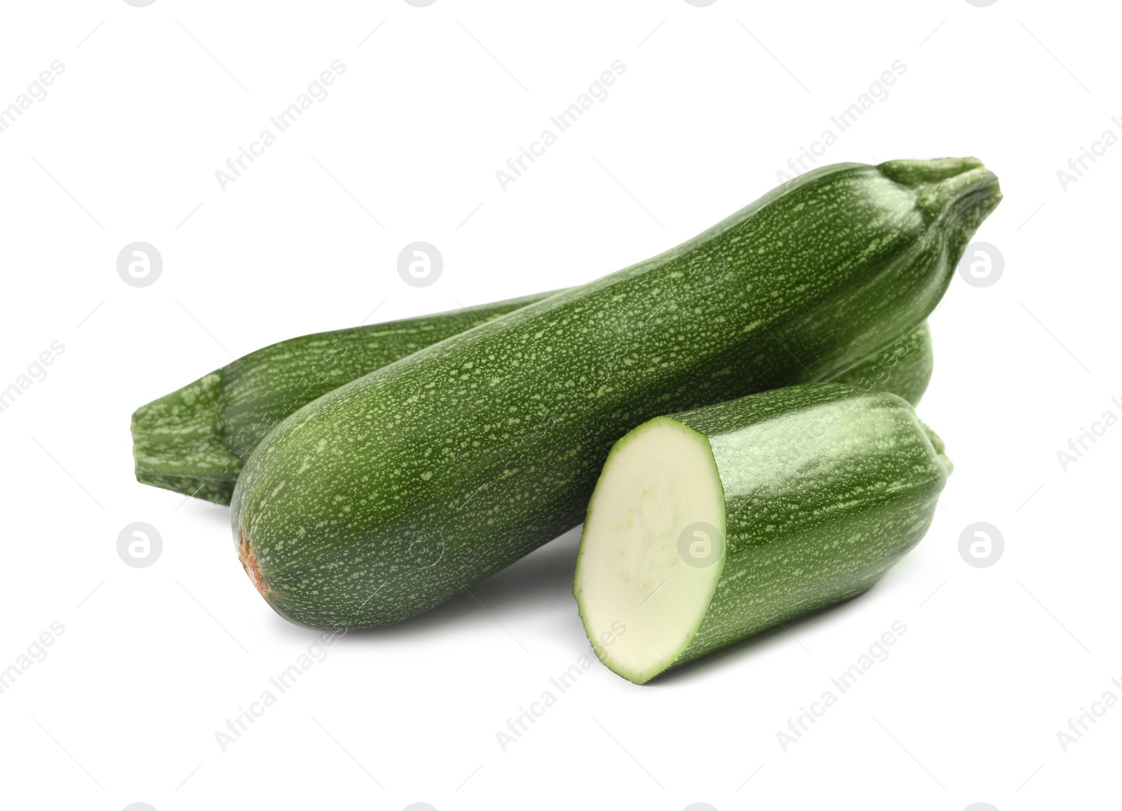 Photo of Whole and cut ripe zucchinis on white background