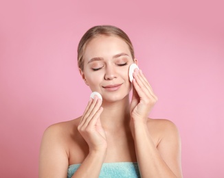 Photo of Beautiful young woman with cotton pad on pink background