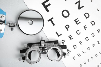 Photo of Different ophthalmologist tools on white table, flat lay