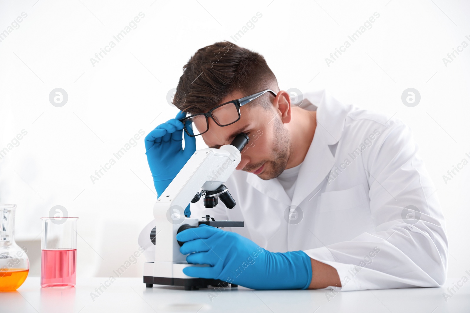 Photo of Scientist using modern microscope at table. Medical research