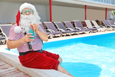 Photo of Authentic Santa Claus with cocktail near pool at resort