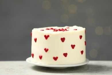 Photo of Bento cake with red cream hearts on grey table. St. Valentine's day surprise