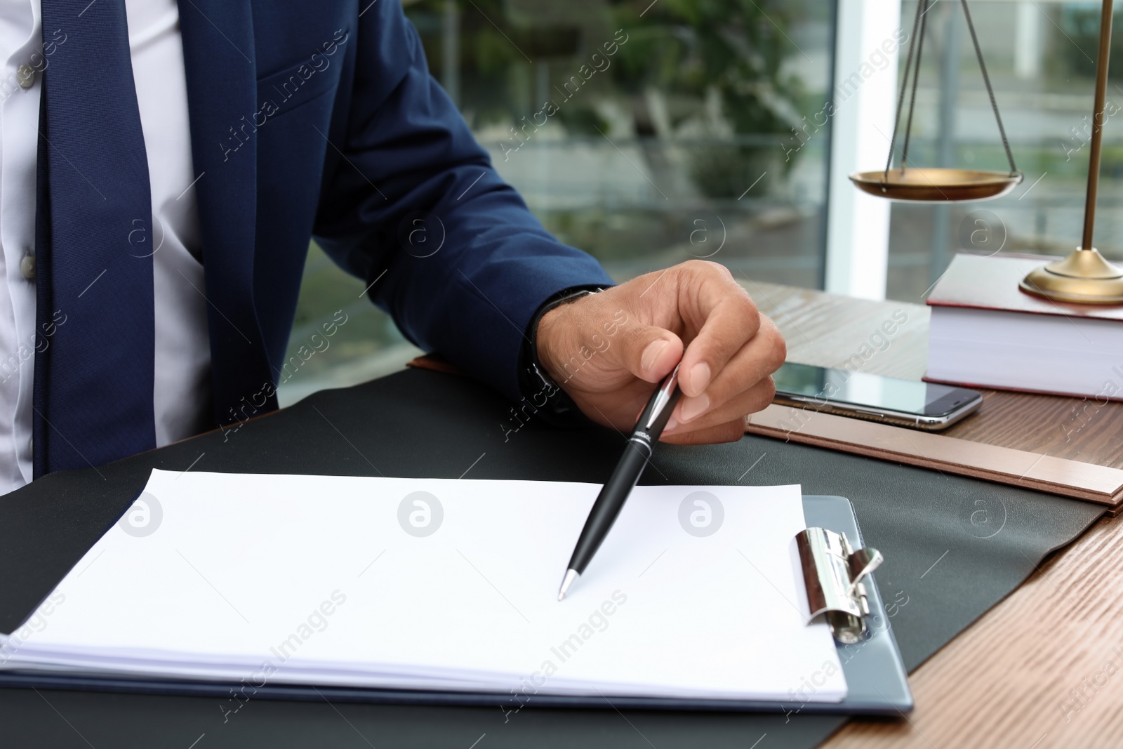 Photo of Male lawyer working with documents at table, closeup. Notary services