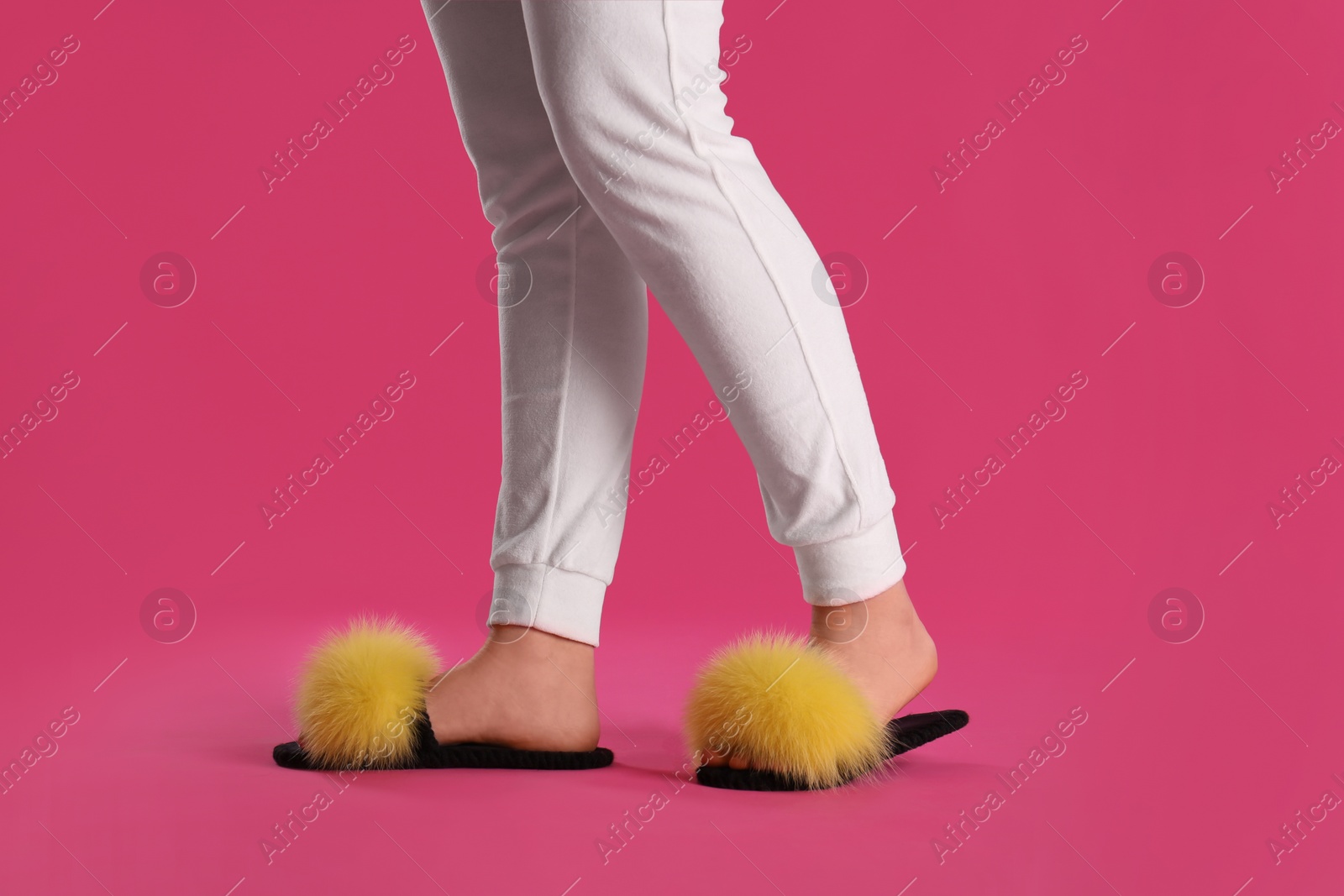 Photo of Woman in fluffy slippers on pink background, closeup