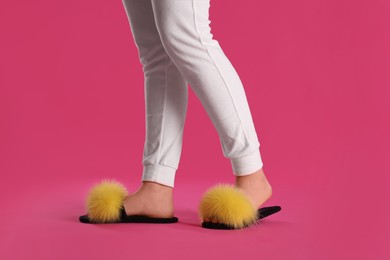 Photo of Woman in fluffy slippers on pink background, closeup