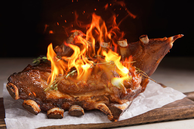 Image of Delicious roasted ribs with flame on table