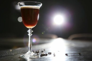 Photo of Glass of martini espresso cocktail on bar counter. Space for text