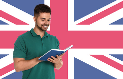 Image of Handsome young man reading book and flag of Great Britain as background. Learning English