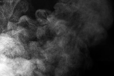 Photo of White steam in air against black background