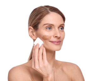 Photo of Woman applying foundation on face with makeup sponge against white background