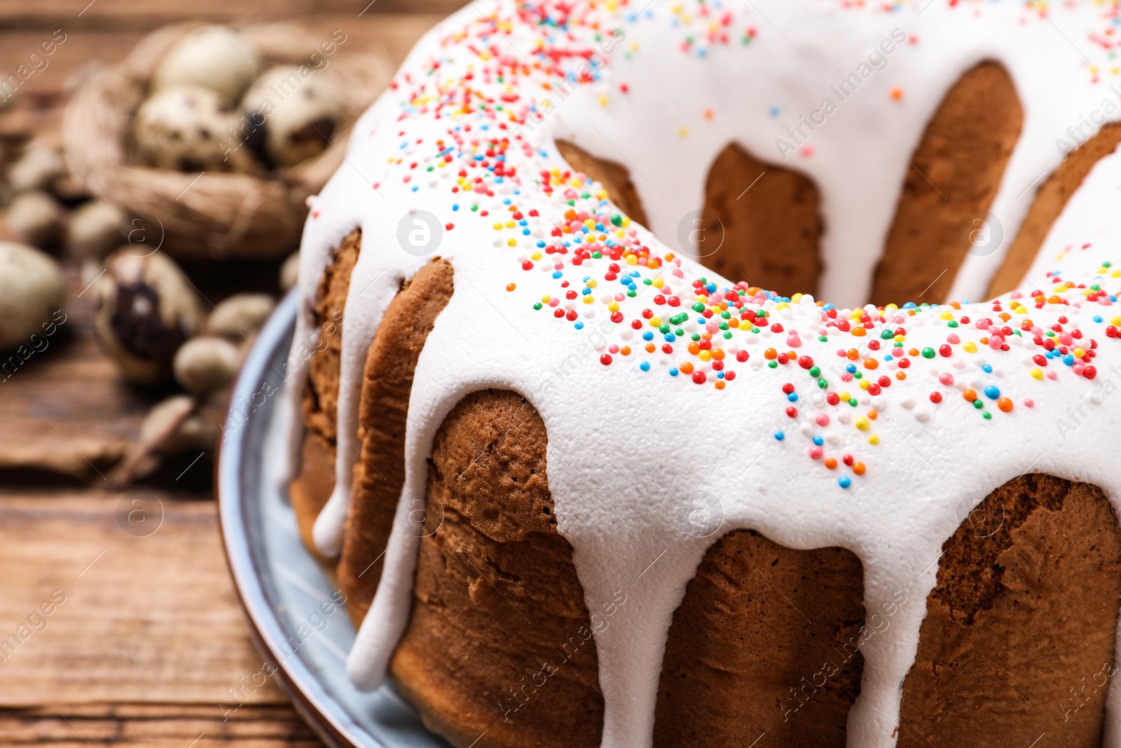 Photo of Glazed Easter cake with sprinkles on wooden table, closeup. Space for text