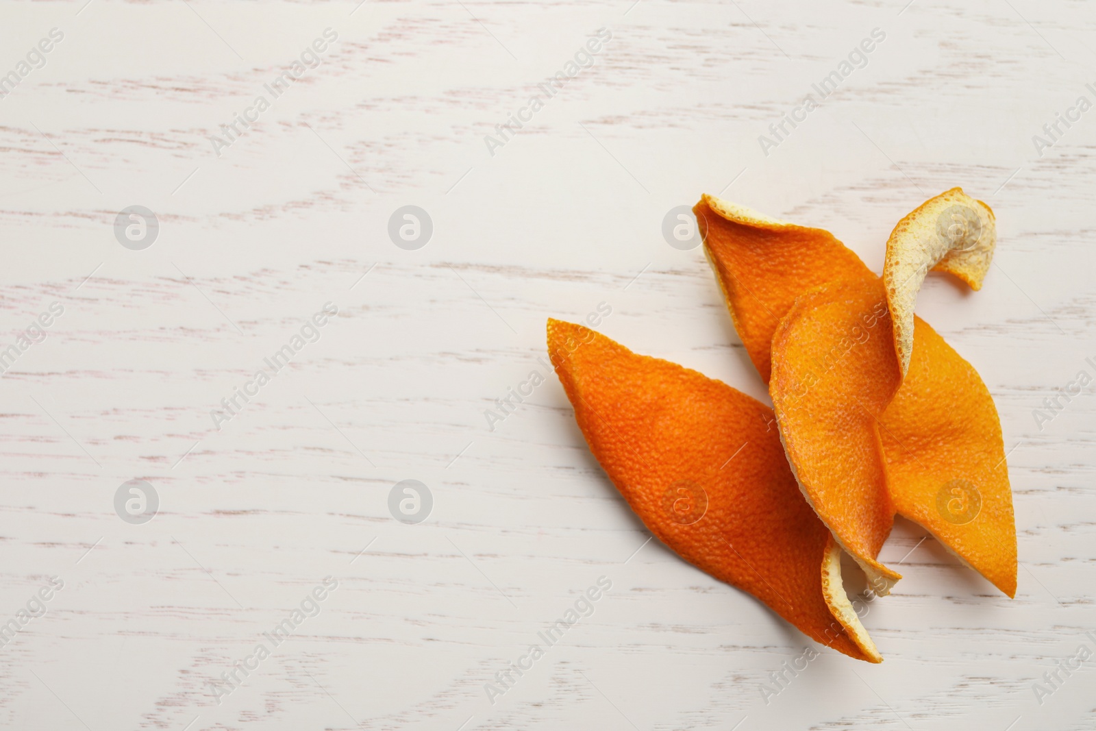 Photo of Dry orange peels on wooden table, top view. Space for text