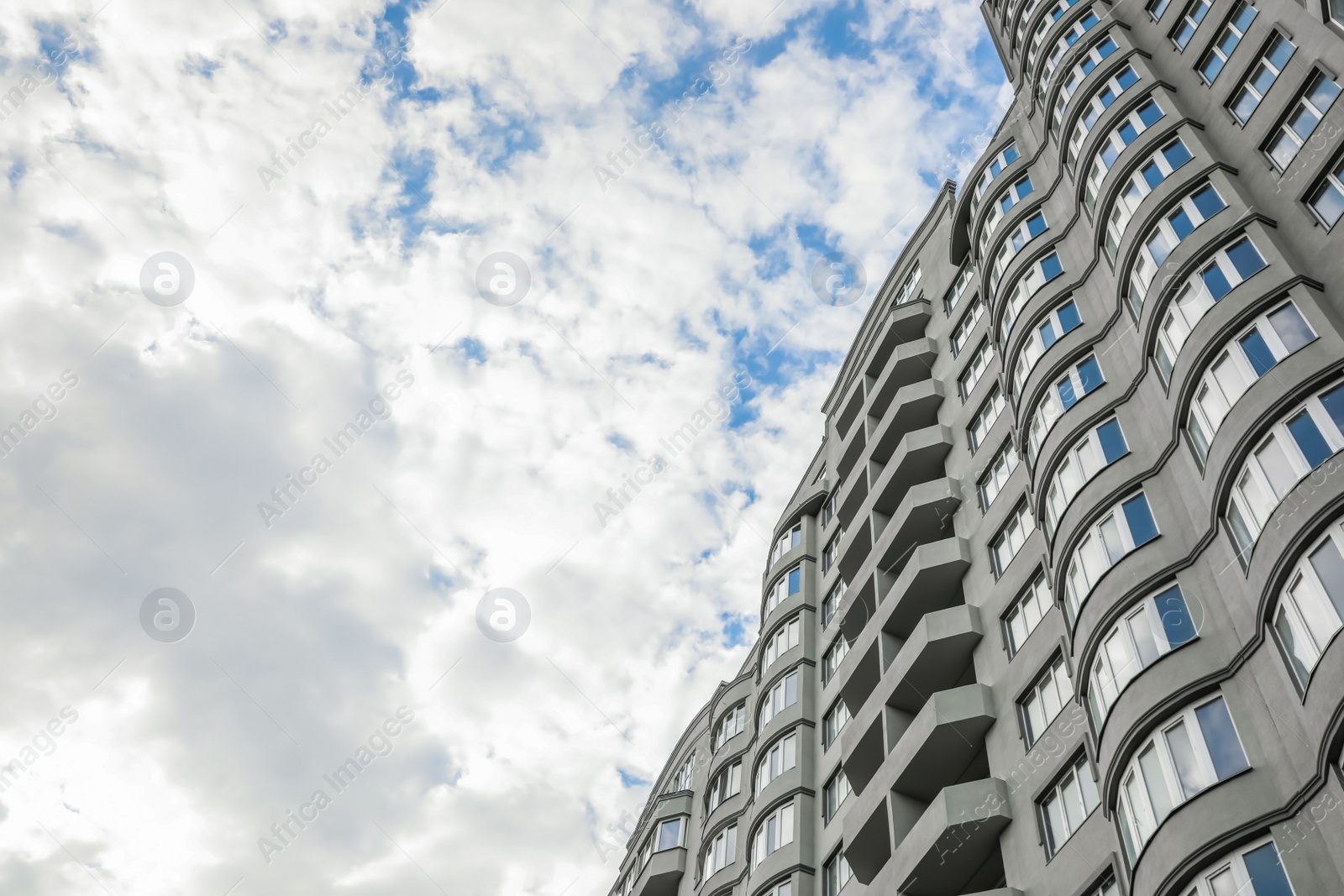 Photo of Modern building under cloudy sky, low angle view