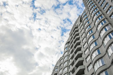 Modern building under cloudy sky, low angle view