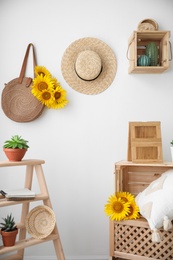 Bag with bouquet of beautiful sunflowers in stylish room interior