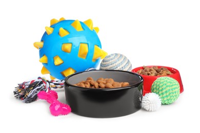 Feeding bowls and toys for pet on white background