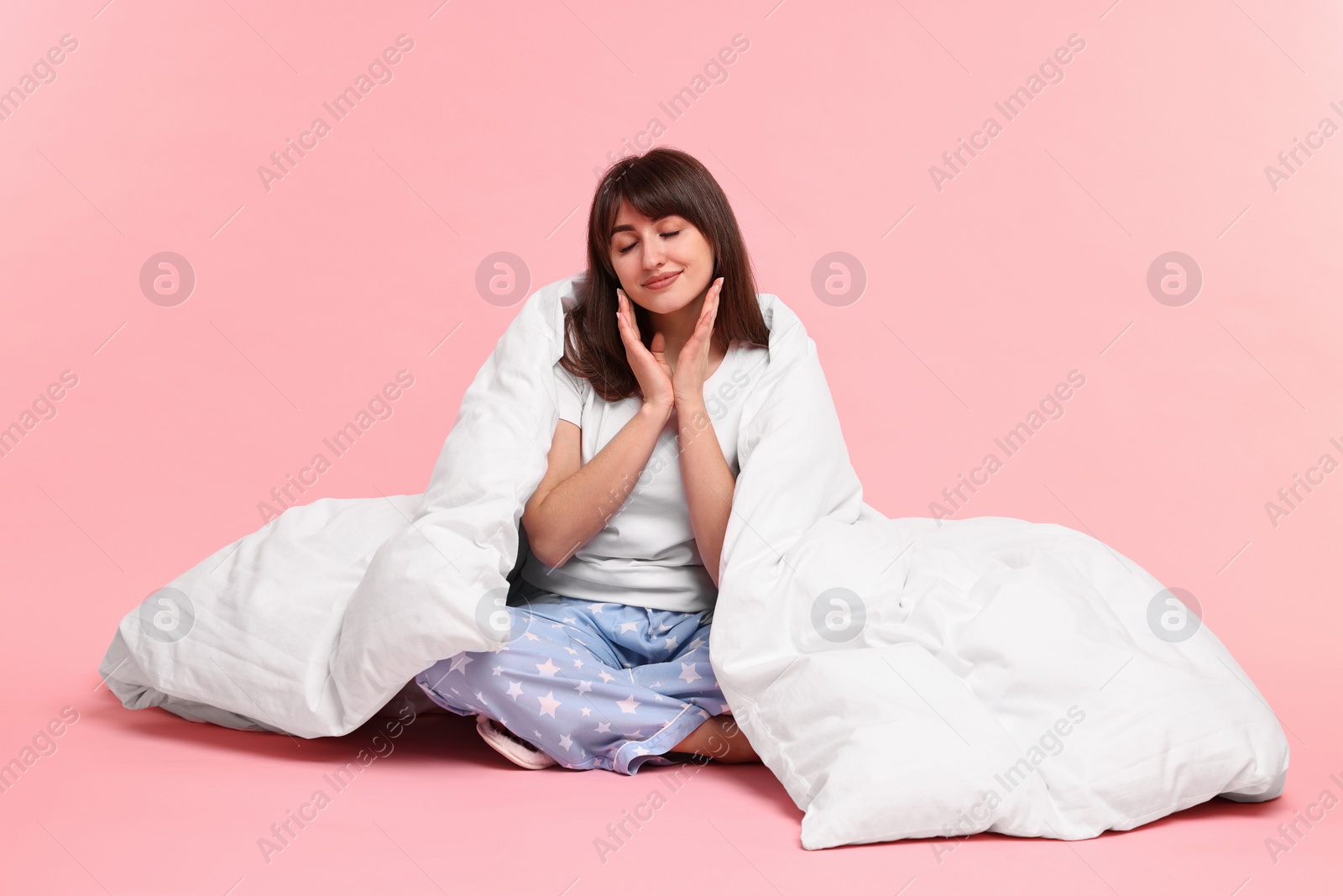 Photo of Woman in pyjama wrapped in blanket on pink background