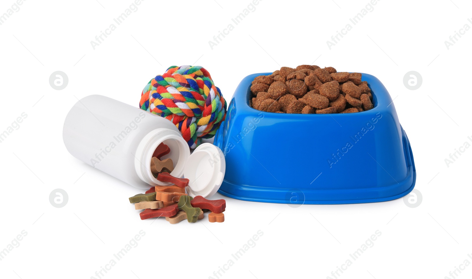 Photo of Dry pet food in bowl, vitamins and toy isolated on white