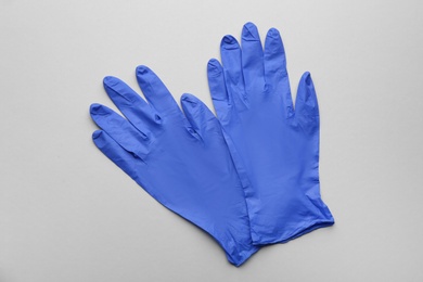 Pair of medical gloves on grey background, flat lay