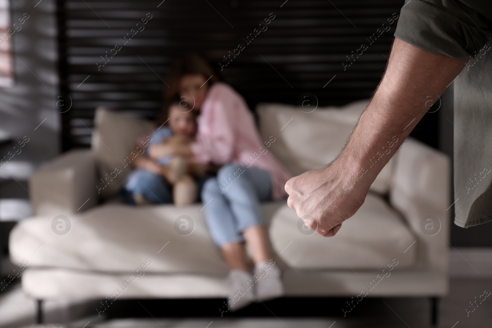 Photo of Man threatening his wife and daughter at home, closeup. Domestic violence