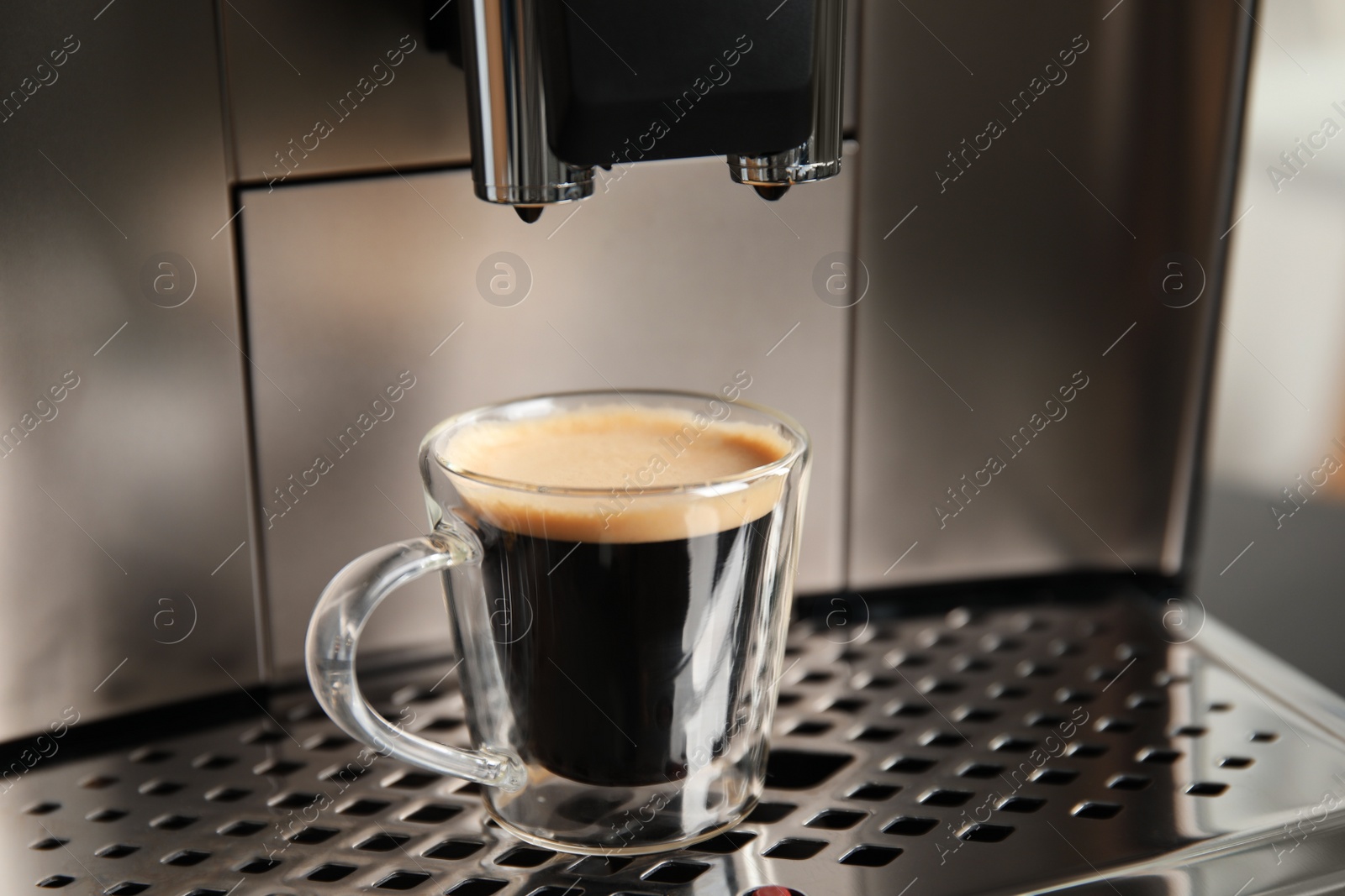 Photo of Espresso machine with cup of fresh coffee on drip tray, closeup