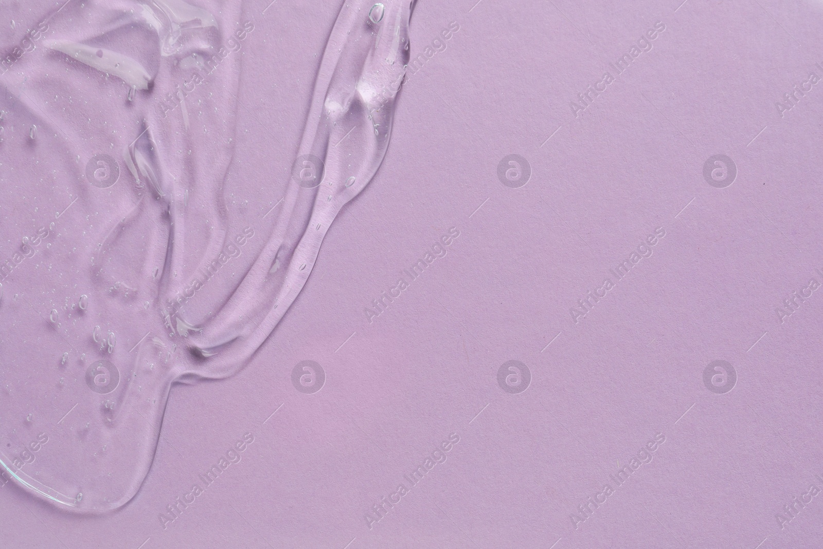 Photo of Clear cosmetic gel on light violet background, top view. Space for text