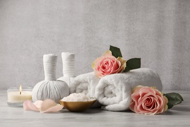 Photo of Composition with spa products, roses and candle on grey wooden table