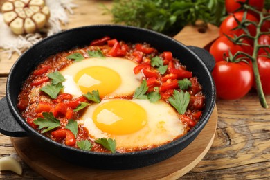 Photo of Delicious Shakshuka on wooden table, closeup view