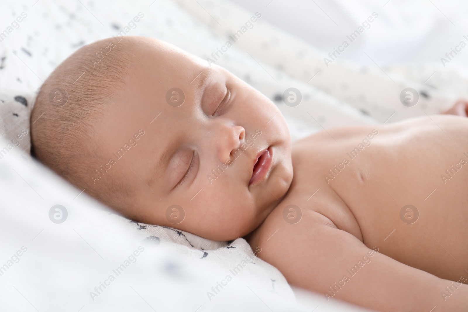 Photo of Cute little baby sleeping on bed, closeup