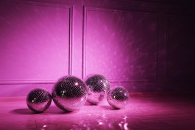 Photo of Shiny disco balls indoors, toned in pink. Space for text