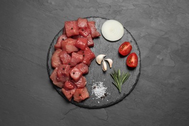 Photo of Raw beef meat and different ingredients for cooking delicious goulash on black table, top view