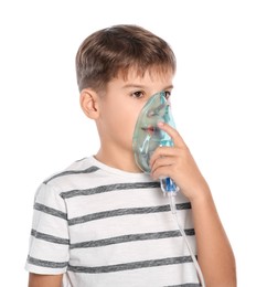 Boy using nebulizer for inhalation on white background