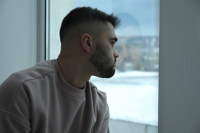 Photo of Sad man looking at window at home