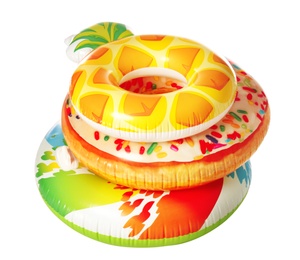 Photo of Different bright inflatable rings on white background. Summer holidays